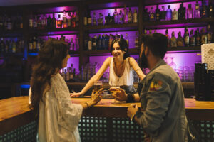 three people is in the pitcher talking to each other a bartender and two customers