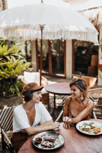 two girls are sitting in a restraunt and talking to Each other